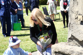 A woman and child share a touching moment laying a wreath at the Cenotaph.