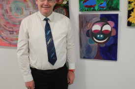 Artist Tommy Carrie poses with his two artworks, ‘Two Giraffes’ and ‘The Happy Flower’.