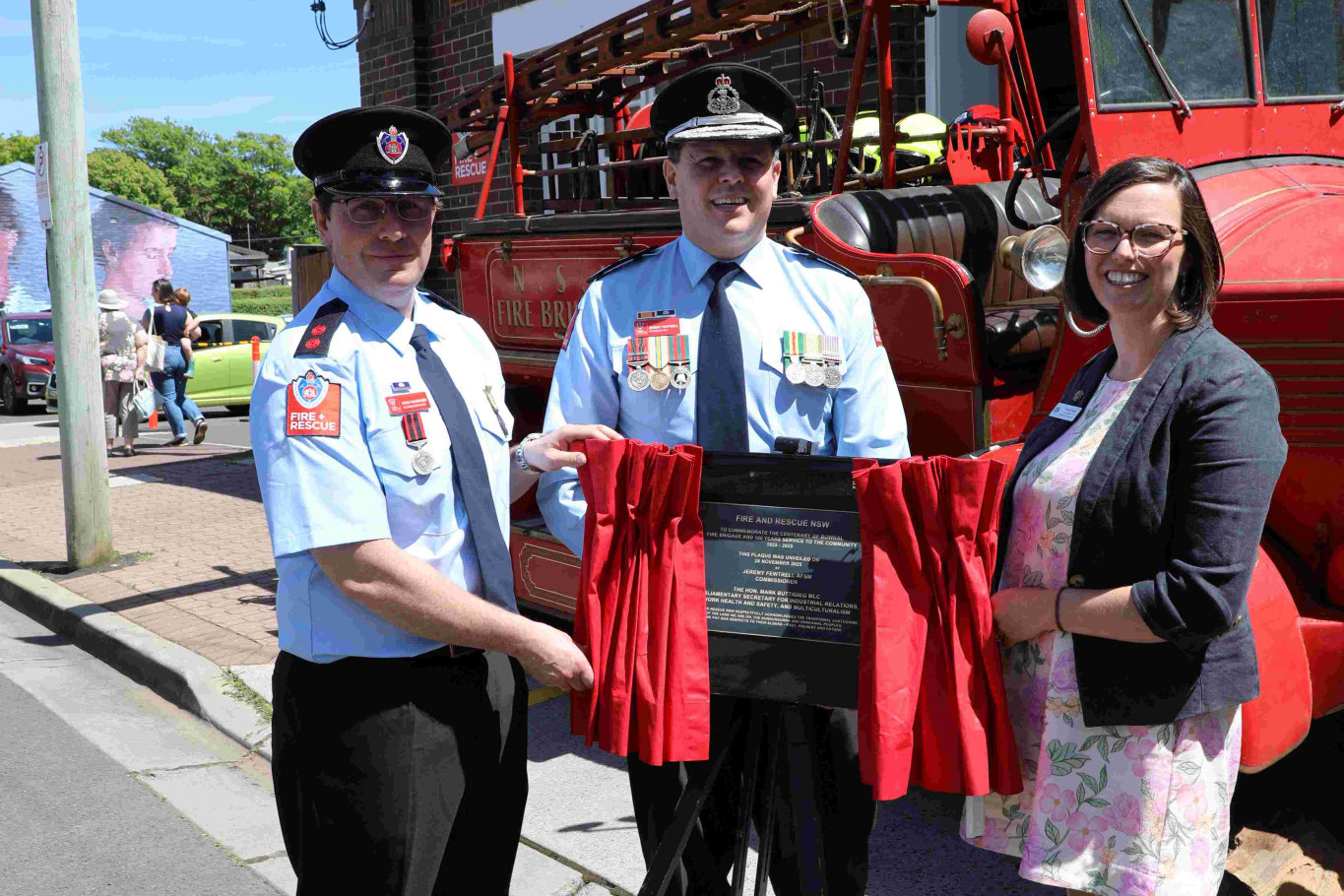 Bowral brigade captain Rudi van der Meer, Fire and Rescue Comissiomer Jeremy Fewtrell and Wingecarribee councillor Tess Duffy uneveil the plaque marking the 100th anniversary of Bowral fire station. Photo Stuart Carless.