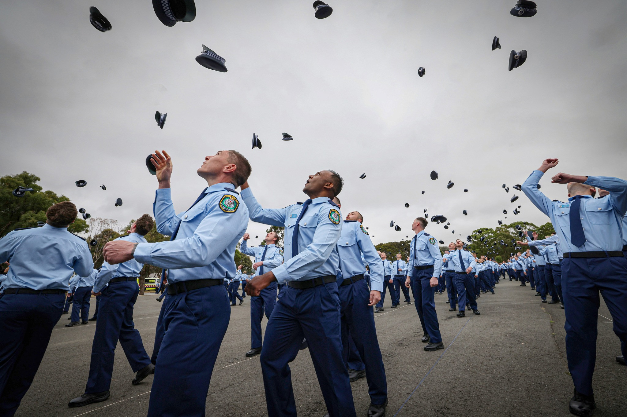 The newly attested probationary constables celebrate by doing the traditional hat throw after the formal attestation ceremony at the Goulburn Police Academy on Friday morning. (Photo: NSW Police)